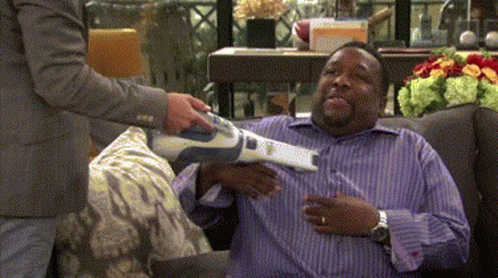A Man In A Purple Shirt Is Being Vacuumed GIF