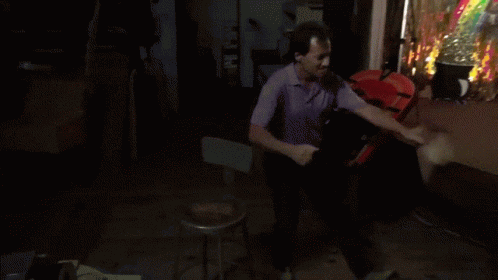 a man in a purple shirt is standing in front of a clown costume