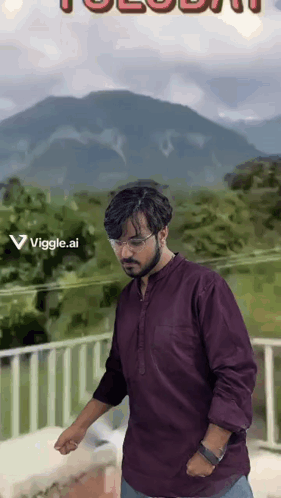 A Man In A Purple Shirt Is Standing On A Balcony With A Mountain In The Background GIF
