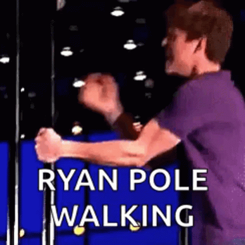 A Man In A Purple Shirt Is Standing On A Pole With His Hands In The Air . GIF