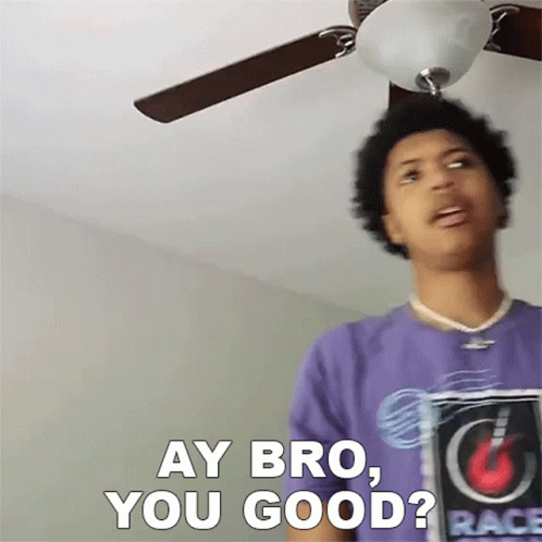 A Man In A Purple Shirt Is Standing Under A Ceiling Fan And Saying " Ay Bro You Good " GIF