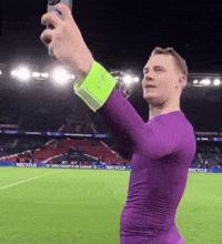 a man in a purple shirt is taking a picture of himself