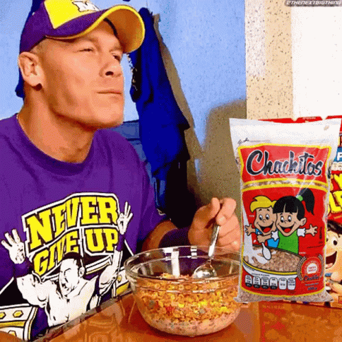 a man in a purple shirt that says never give up is eating cereal
