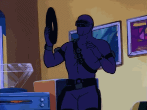 A Man In A Purple Suit Is Holding A Record In His Hand GIF