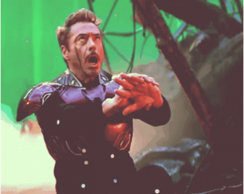 A Man In A Purple Suit Is Holding Something In His Hand GIF