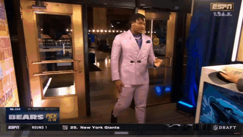 A Man In A Purple Suit Is Standing In Front Of A Door That Says Espn GIF