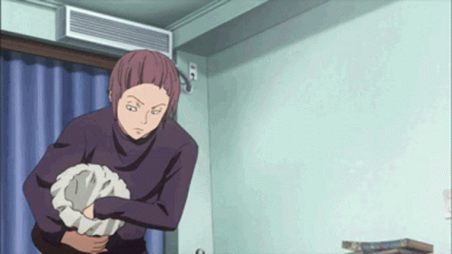 A Man In A Purple Sweater Is Holding A Pillow In His Hand GIF