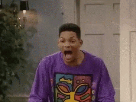 A Man In A Purple Sweater Is Screaming In A Room . GIF