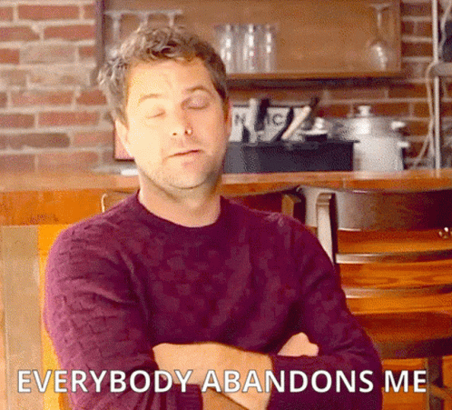 A Man In A Purple Sweater Sits In A Chair With His Arms Crossed And Says Everybody Abandons Me . GIF