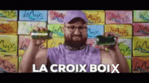 A Man In A Purple Tank Top Is Holding Two Cans Of Soda And The Words La Croix Boix Are Above Him GIF