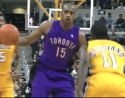 A Man In A Purple Toronto Jersey Holds A Basketball GIF