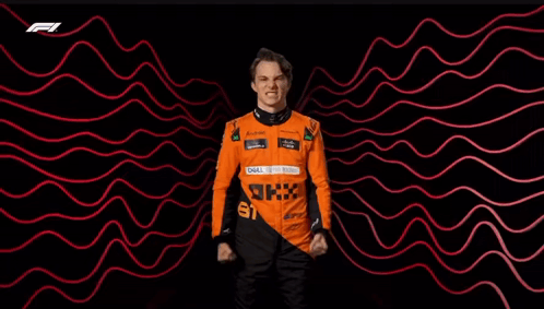 A Man In A Racing Suit Is Standing In Front Of A Red And Black Background . GIF