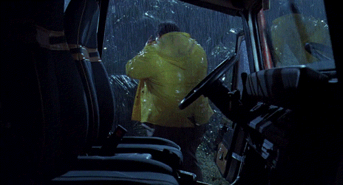 a man in a raincoat is driving a car