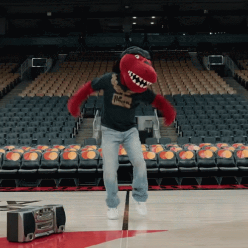 A Man In A Raptors Mascot Costume Is Jumping In The Air GIF