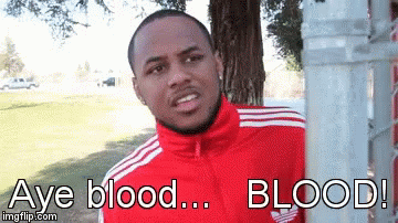 A Man In A Red Adidas Jacket Is Standing Next To A Tree GIF