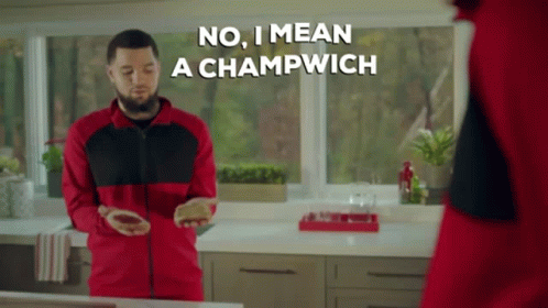 A Man In A Red And Black Jacket Says No I Mean A Champwich While Standing In A Kitchen GIF