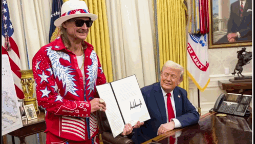 A Man In A Red And White Outfit Holds A Signed Document Next To A Man In A Suit GIF