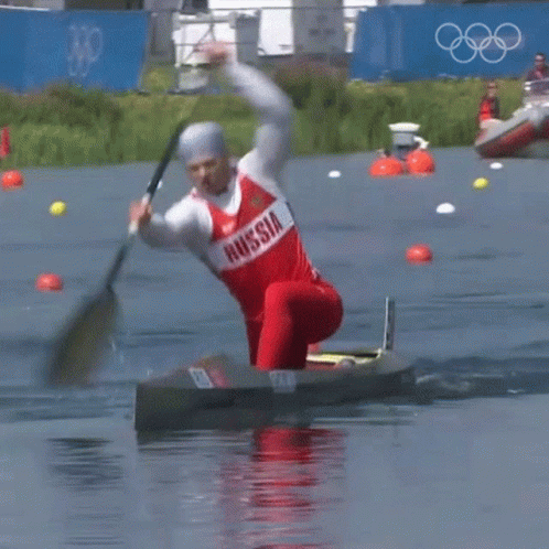 A Man In A Red And White Russia Shirt Is Paddling A Kayak GIF