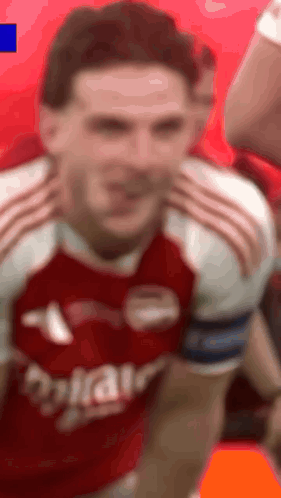 A Man In A Red And White Soccer Jersey Is Making A Face . GIF