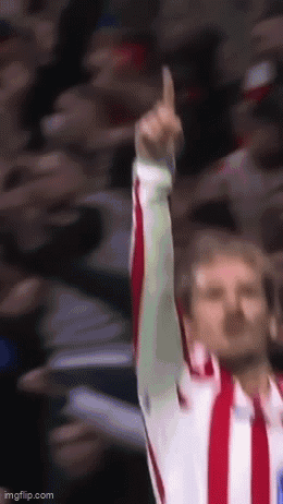 A Man In A Red And White Striped Shirt Is Raising His Finger Up In The Air GIF