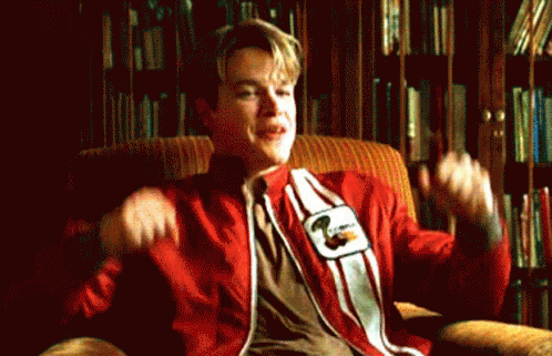 A Man In A Red And White Striped Shirt Is Sitting In A Chair With His Arms Outstretched . GIF