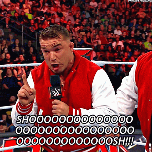 A Man In A Red And White Varsity Jacket Is Holding A Microphone And Says Shoo GIF