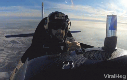 A Man In A Red Bull Helmet Sits In A Small Plane GIF