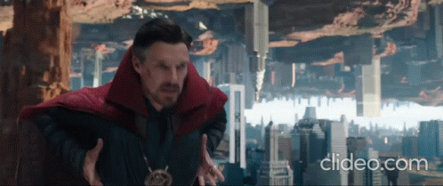 A Man In A Red Cape Is Standing In Front Of A City With The Words Clideo.com Below Him . GIF