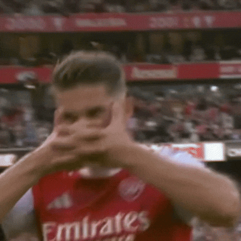 A Man In A Red Emirates Jersey Is Covering His Face With His Hands . GIF