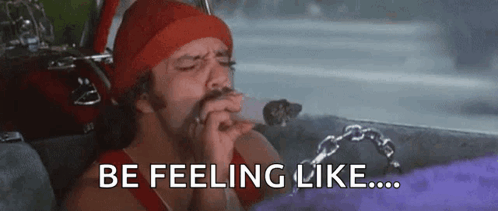 A Man In A Red Hat Is Smoking A Cigarette In A Car And The Words `` Be Feeling Like '' Are Above Him . GIF