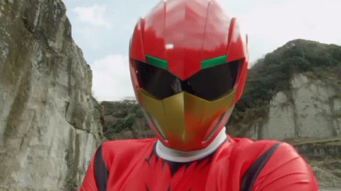 A Man In A Red Helmet And Sunglasses Stands In Front Of A Mountain GIF