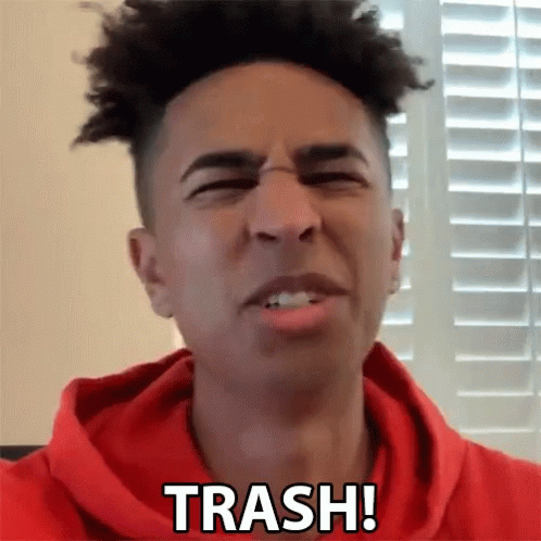 A Man In A Red Hoodie Says Trash In Front Of A Window GIF