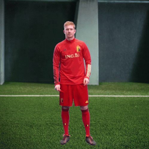 A Man In A Red Ing Jersey Stands On A Green Field GIF