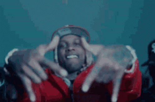 A Man In A Red Jacket And Hat Is Making A Hand Gesture With His Fingers . GIF