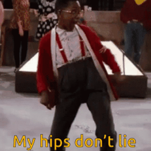 A Man In A Red Jacket And Suspenders Is Dancing With The Words " My Hips Don 'T Lie " Below Him GIF