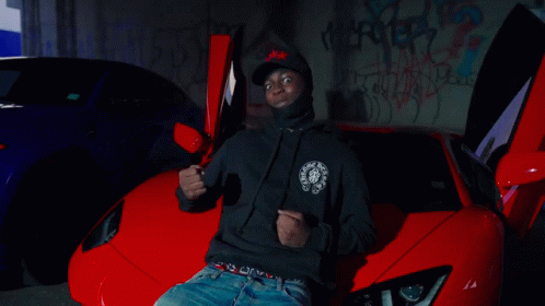 A Man In A Red Jacket Is Dancing In Front Of A Group Of People GIF