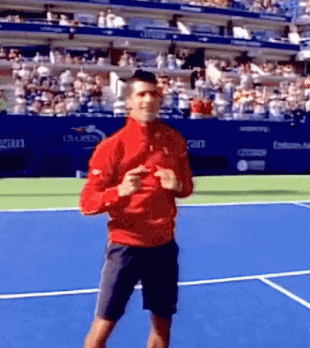 A Man In A Red Jacket Is Dancing On A Tennis Court GIF