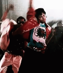A Man In A Red Jacket Is Dancing With A Group Of People In A Room . GIF