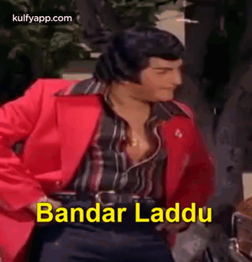 A Man In A Red Jacket Is Dancing With The Words Bandar Laddu Written In Yellow . GIF