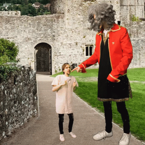 A Man In A Red Jacket Is Pointing At A Little Girl GIF