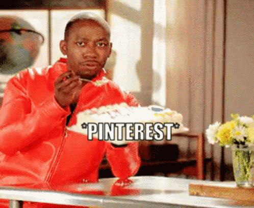 A Man In A Red Jacket Is Sitting At A Table Eating A Cake With The Words Pinterest Above Him GIF