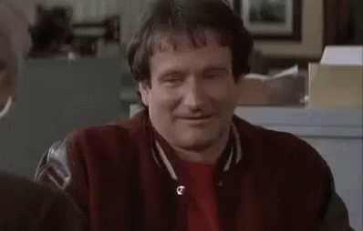 A Man In A Red Jacket Is Sitting At A Table With His Eyes Closed And Smiling . GIF