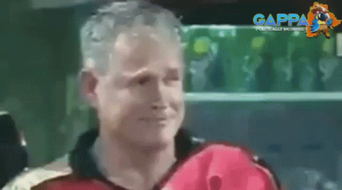 A Man In A Red Jacket Is Smiling In Front Of A Green Shelf With Gappa Written On It GIF