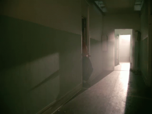 A Man In A Red Jacket Is Standing In Front Of A Door GIF