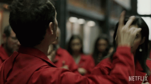 A Man In A Red Jacket Is Standing In Front Of A Group Of People With Netflix Written On The Bottom Of The Screen GIF