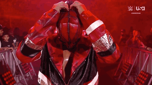 A Man In A Red Jacket Is Taking A Picture Of Himself With A Camera . GIF
