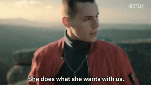A Man In A Red Jacket Is Talking To A Woman Who Is Standing Next To Him . GIF