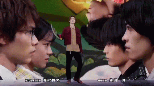 A Man In A Red Jacket Stands In Front Of A Group Of People With Asian Writing On The Bottom GIF