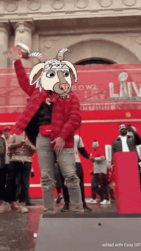 A Man In A Red Jacket With A Goat Mask On His Head Holds A Trophy GIF