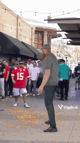 A Man In A Red Jersey With The Number 15 On It Stands In Front Of A Crowd Of People GIF